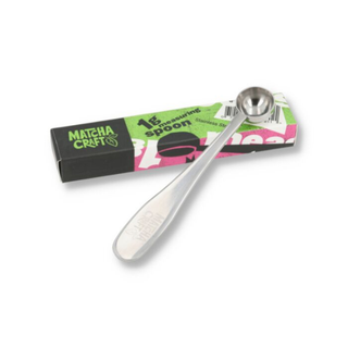 Stainless steel measuring spoon with packaging on a white background