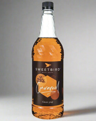 Bottle of Sweetbird Caramel syrup on a gray background
