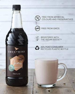 Bottle of Sweetbird chai with a glass of chai on a wooden surface, featuring sustainability claims.
