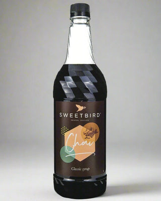 Bottle of Sweetbird Chai syrup on a gray background