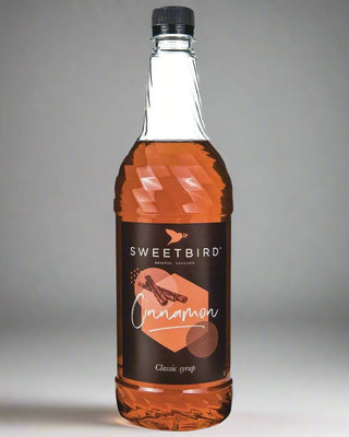 Bottle of Sweetbird Cinnamon syrup on a gray background