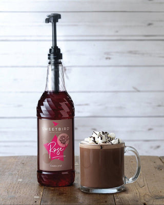 Bottle of Sweetbird Creative Rose Syrup, 1 litre bottle, and Rose Hot Chocolate drink

